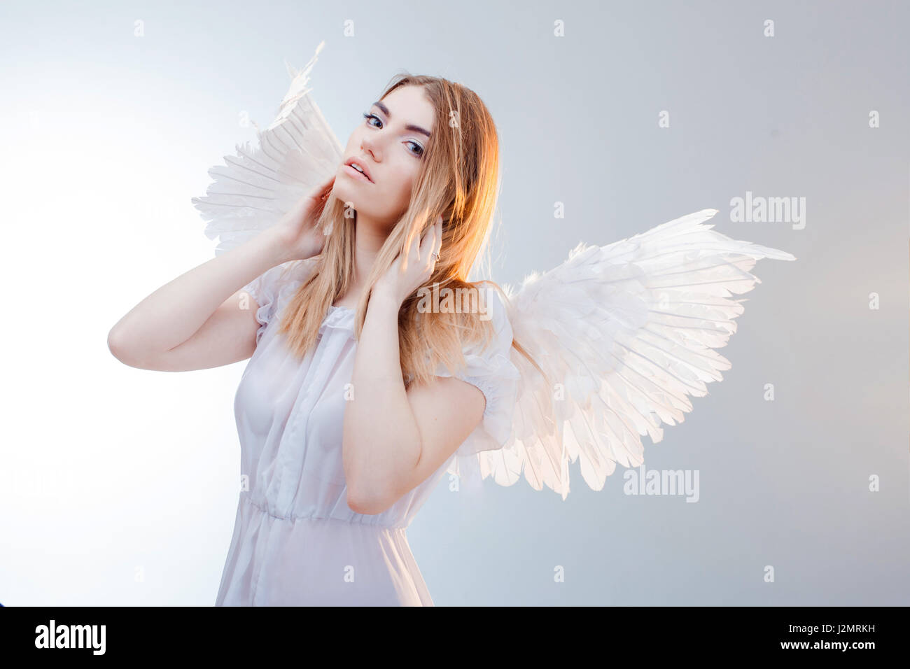 Un ángel del cielo. Los jóvenes, maravillosa chica rubia en la imagen de un  ángel con alas blancas Fotografía de stock - Alamy