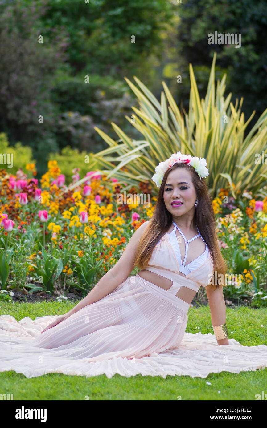 Modelo Filipino belleza del sudeste asiático con un parque local como telón de fondo, en el Reino Unido. Foto de stock