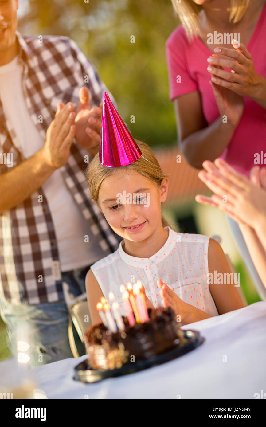 Chica con gorro de fiesta y la tarta de cumpleaños celebrar cumpleaños Foto de stock