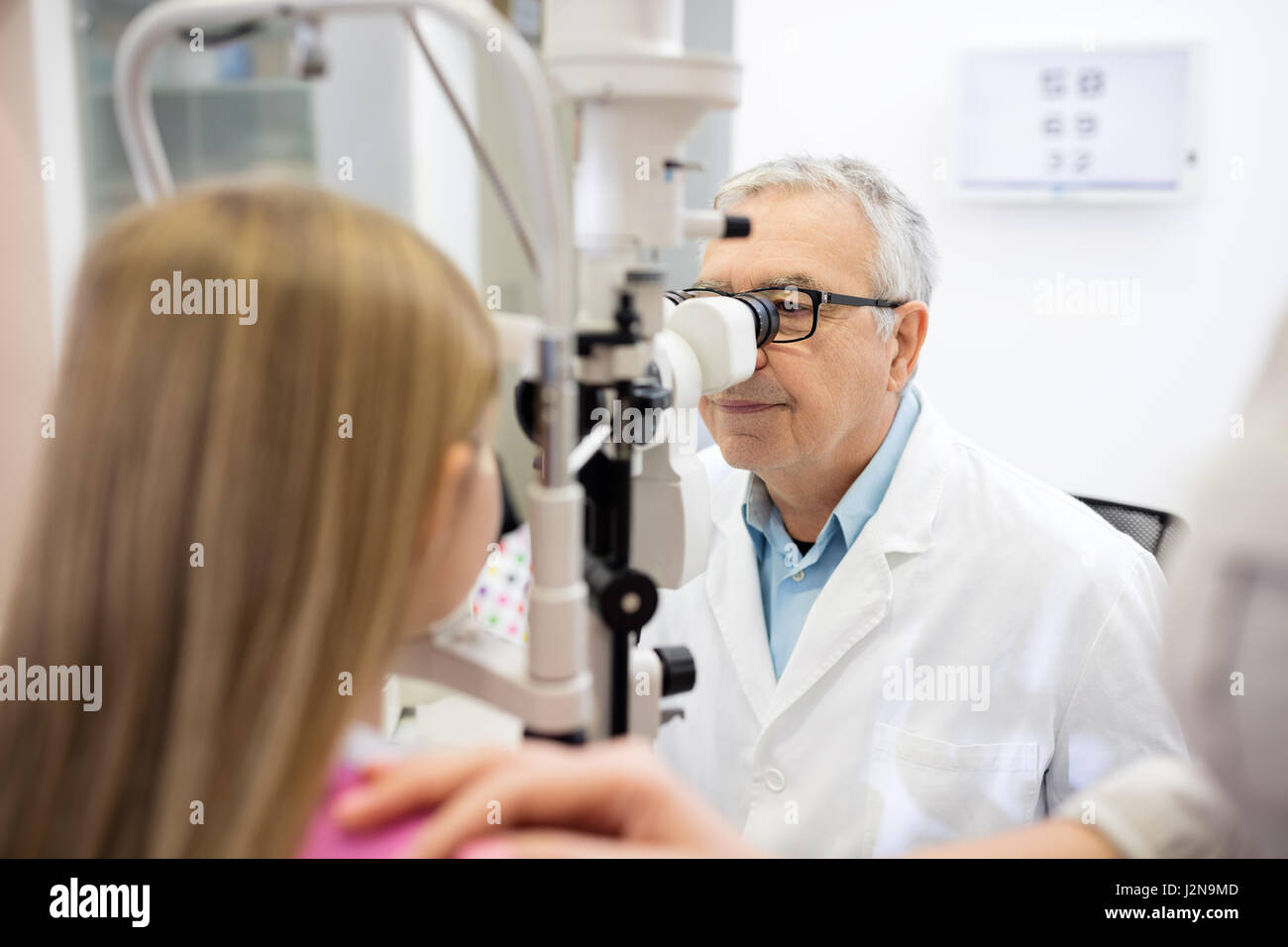 El oftalmólogo determina dioptría a la niña en una clínica oftalmológica Foto de stock