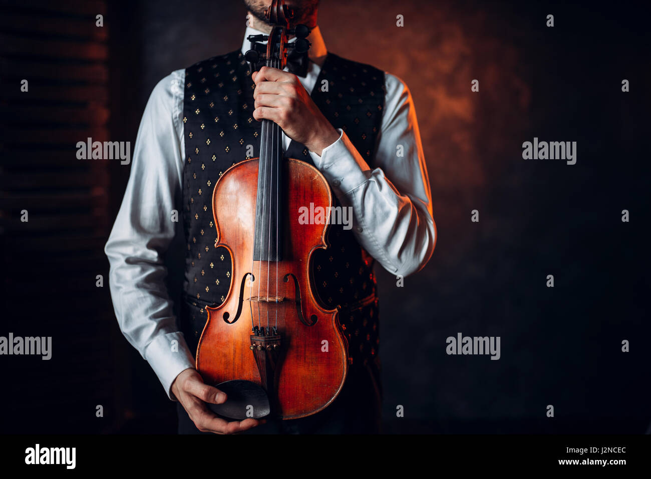 Retrato de persona de sexo masculino la celebración de violín de madera. Fiddler con instrumento musical Foto de stock