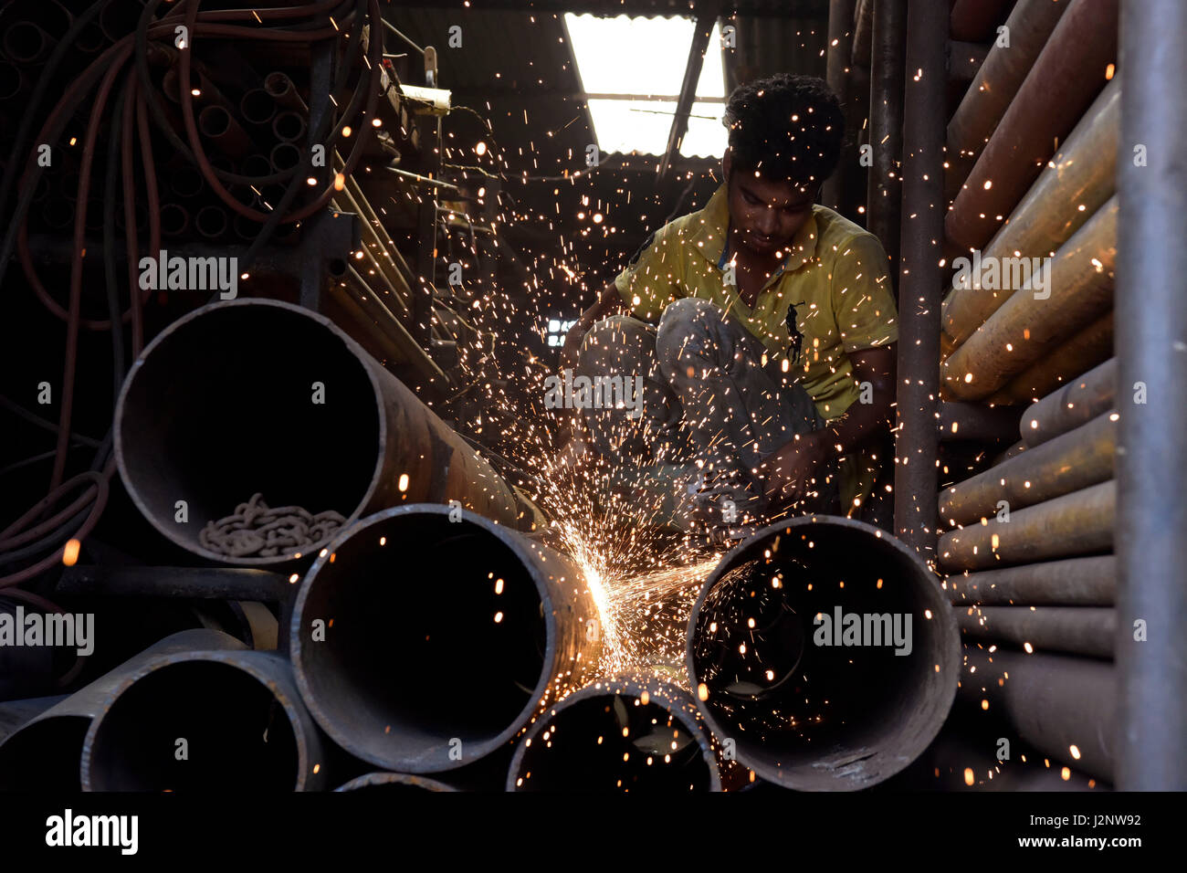 Dhaka, Bangladesh. 30 abr, 2017. Un trabajador de Bangladesh cortes en trozos de tubería de hierro viejo para reciclarlos en una plancha rerolling fábrica en Dhaka, Bangladesh. Crédito: SK Hasan Ali/Alamy Live News Foto de stock