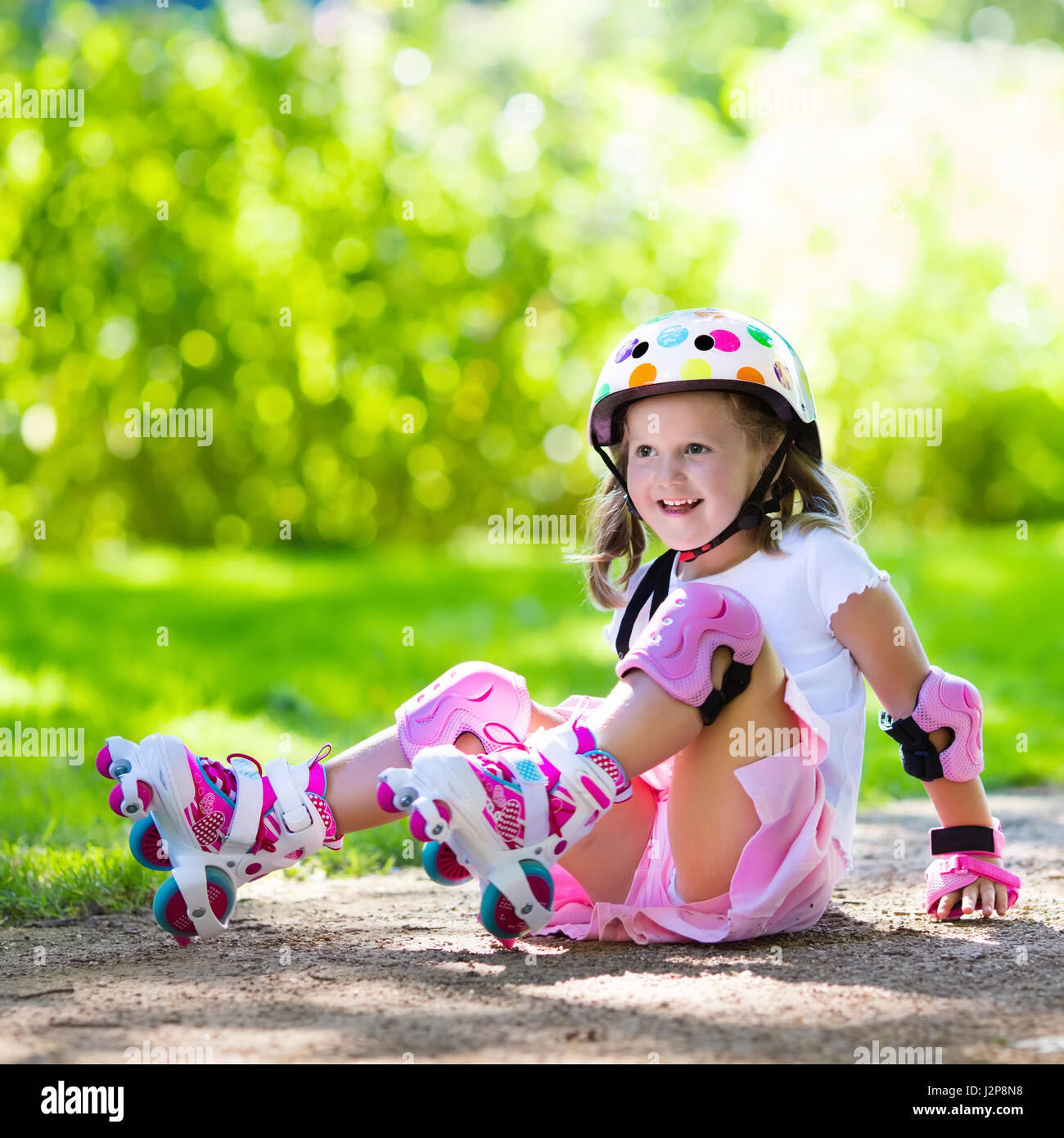 Niña aprendiendo a patines en el parque soleado de verano. Un niño llevaba  protección rodilleras y coderas, muñequeras y casco de seguridad SEGURO DE  ROLLE Fotografía de stock - Alamy