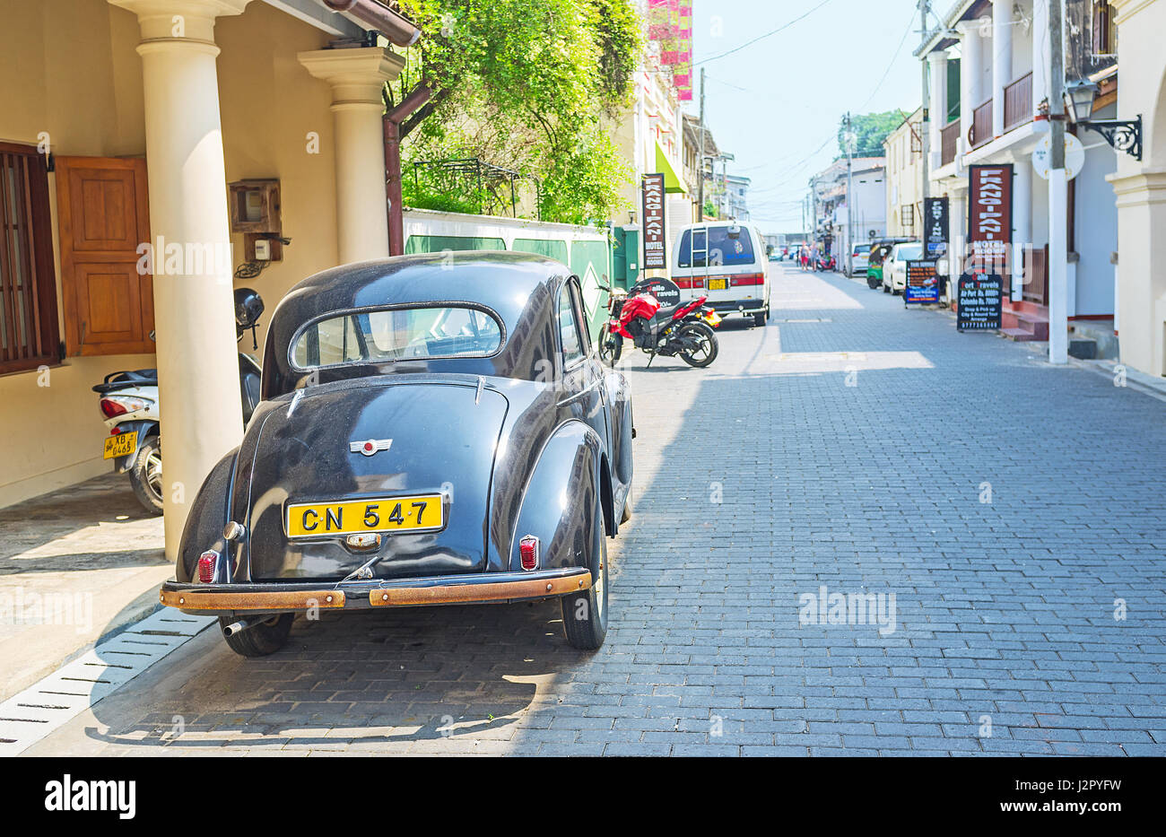 GALLE, SRI LANKA - Diciembre 4, 2016: La calle angosta de Galle Fort con el Morris Minor Classic Car junto a las columnas de impresoras Hotel, en diciem Foto de stock