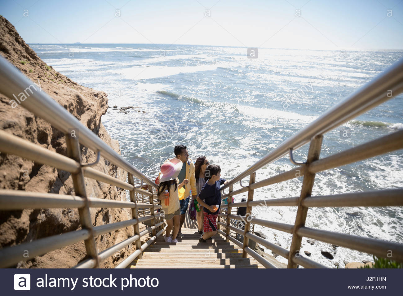 Latino Family ascendente escaleras arriba sunny ocean Foto de stock