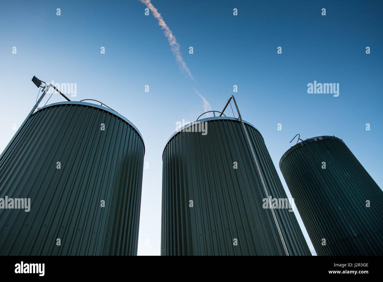 3 actividades queseras torres de acero inoxidable contra un cielo azul profundo Foto de stock