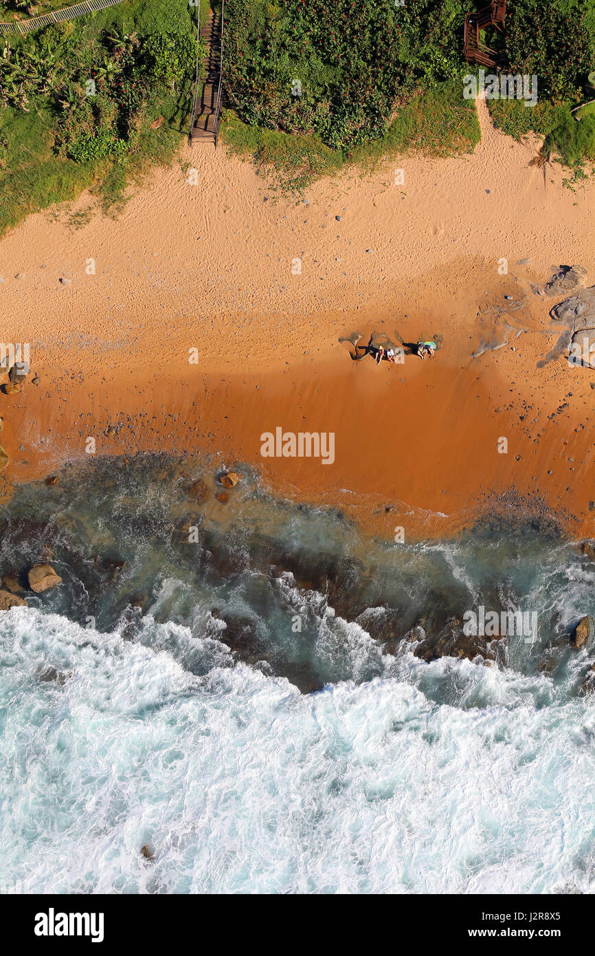 Una perspectiva aérea de las olas rompiendo a lo largo de una costa rocosa. Foto de stock