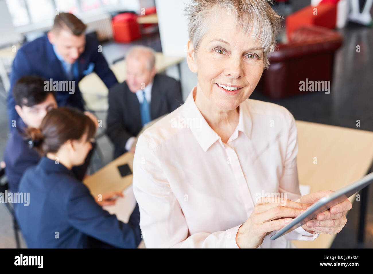 Mujer senior en comunicación empresarial con su equipo de taller Foto de stock