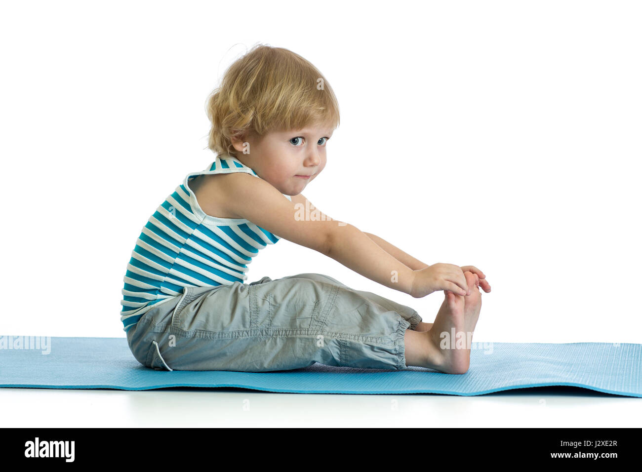 Niño practicando yoga, estiramiento en ejercicio vistiendo ropa deportiva. Kid aislado sobre fondo blanco. Foto de stock