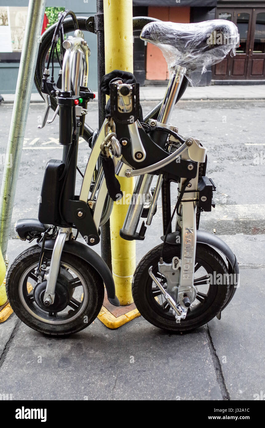 Una bicicleta eléctrica plegable KiwkFold bloqueado para un andamio de polo en la zona del Soho de Londres. Foto de stock