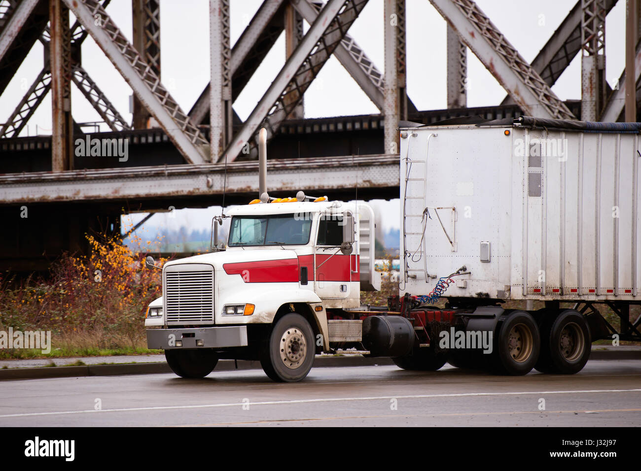 Antiguo big rig poderoso capó blanco semicamión con remolque a granel