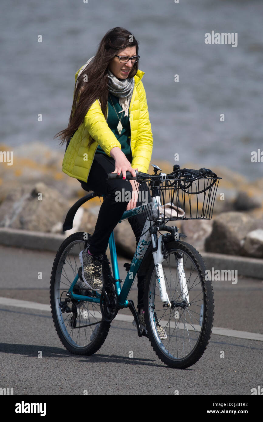 Un ciclista recorre una bicicleta en Cardiff Bay barrage durante el cálido clima soleado en el mayo festivo en Cardiff, Gales del Sur. el Met Office advirtió de Foto de stock