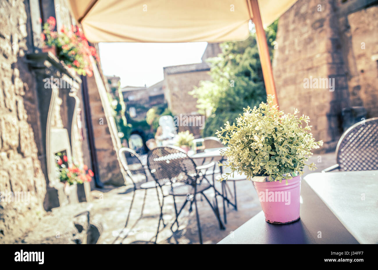Café con mesas y sillas en una antigua calle en Europa con estilo Instagram vintage retro efecto de filtro Foto de stock