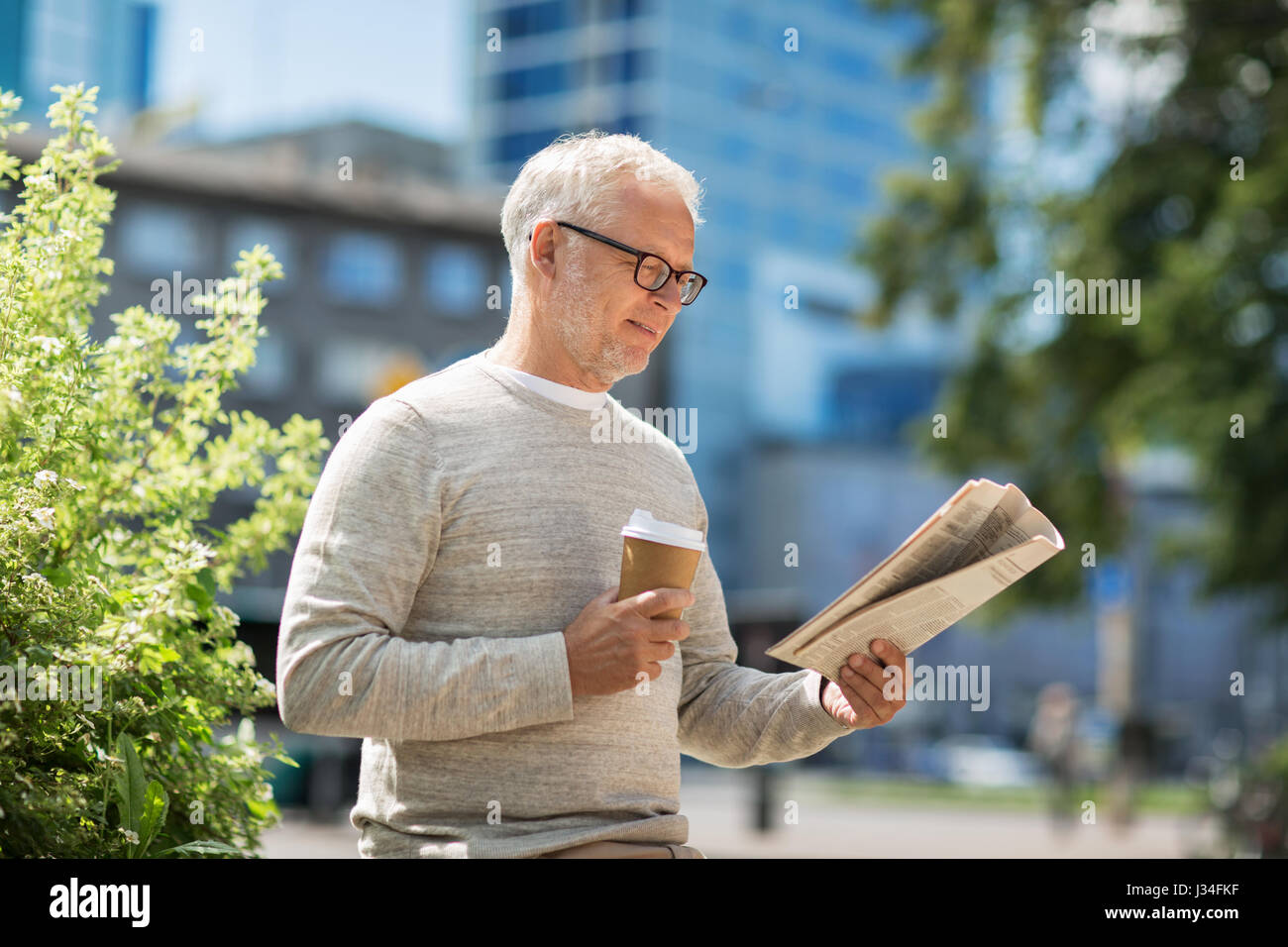 Altos hombre leyendo el periódico y bebiendo café Foto de stock