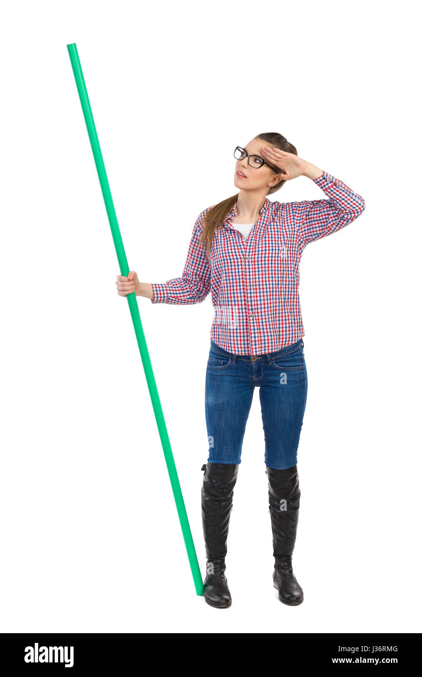 Mujer joven en vidrios, jeans, botas negras y camisa de leñadores y  manteniendo permanente verde chroma key stick, mirando y saludando.  Longitud total s Fotografía de stock - Alamy