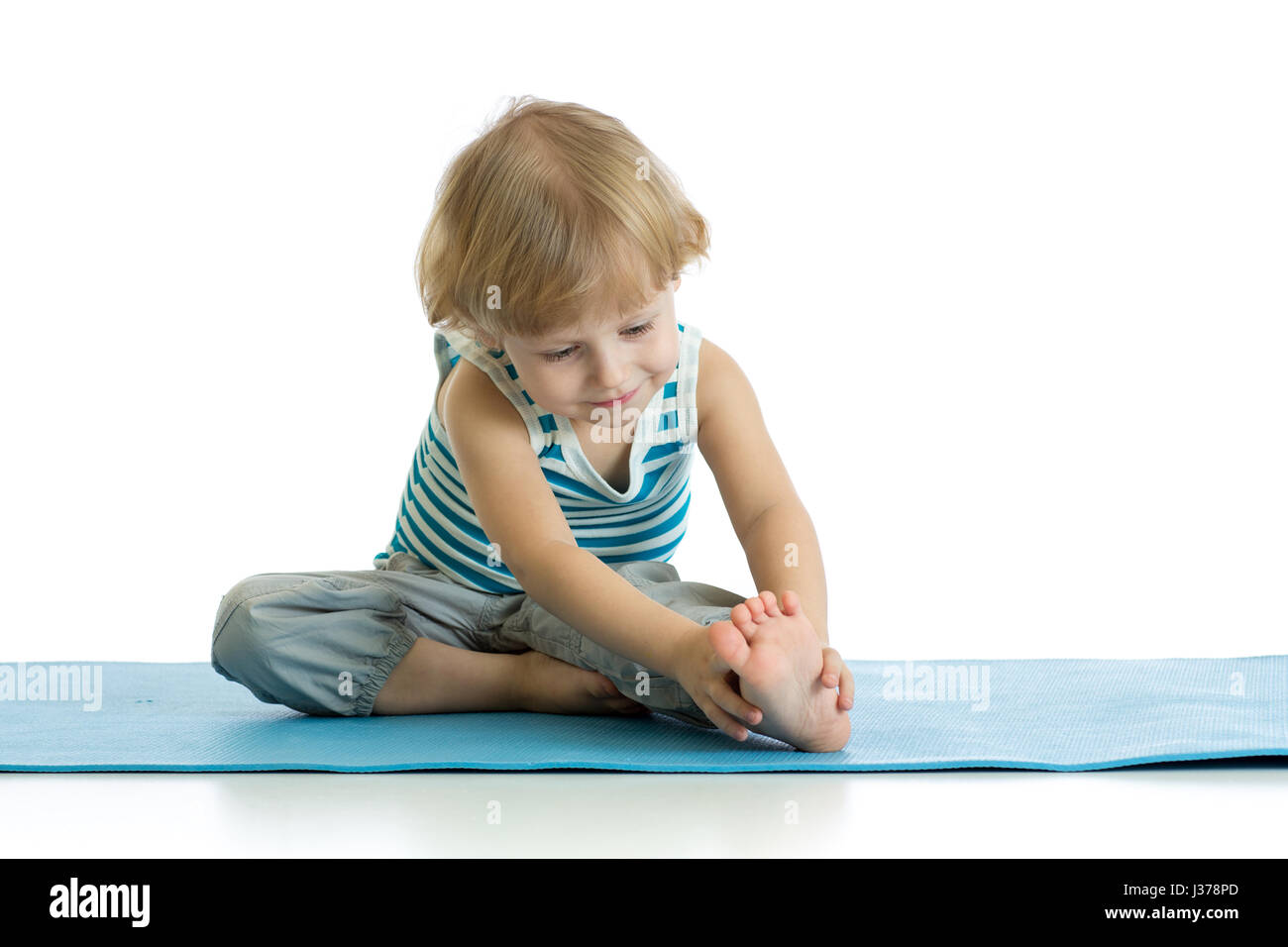 Niño practicando yoga, estiramiento en ejercicio vistiendo ropa deportiva. Kid aislado sobre fondo blanco. Foto de stock