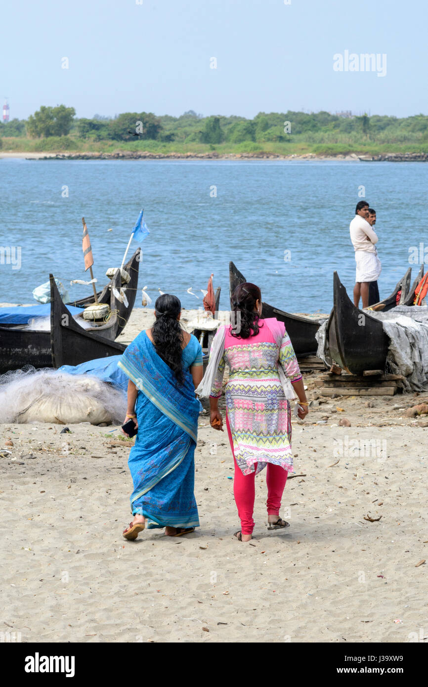 Dos mujeres vistiendo ropa tradicional paseo por la playa para ver los  barcos de pesca en el fuerte Kochi (Cochin), Kerala, Sur de la India, el  sur de Asia Fotografía de stock -