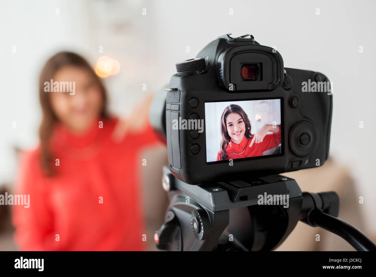 Mujer con cámara grabando vídeos en casa Foto de stock