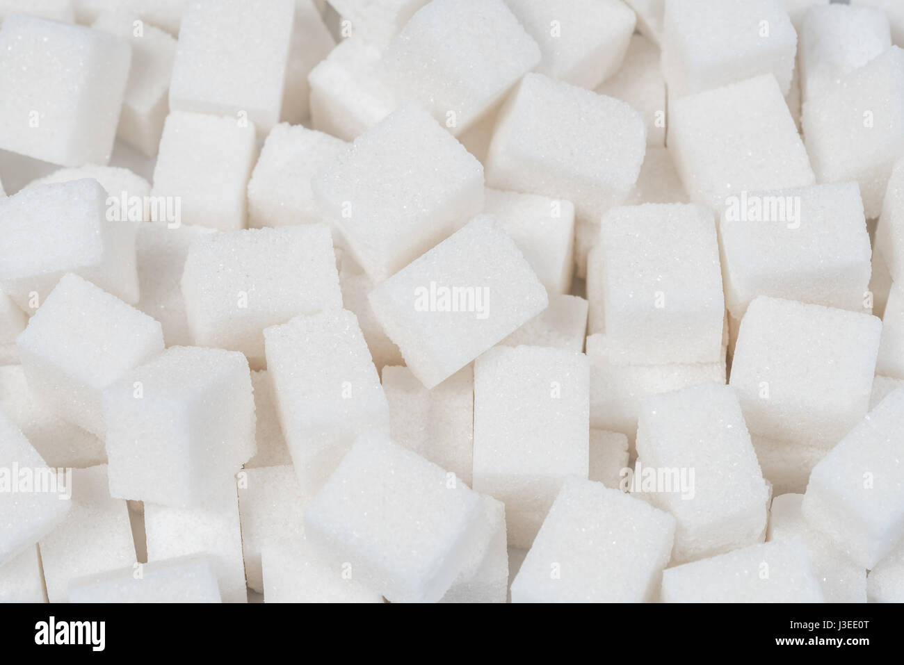 Azúcar dulce ingrediente alimentario de fondo con un primer plano de un montón de deliciosos protuberancias blancas de cubos como un símbolo de cocinar y hornear, y la dieta de los riesgos para la salud relacionados con la diabetes y el consumo de calorías. Foto de stock