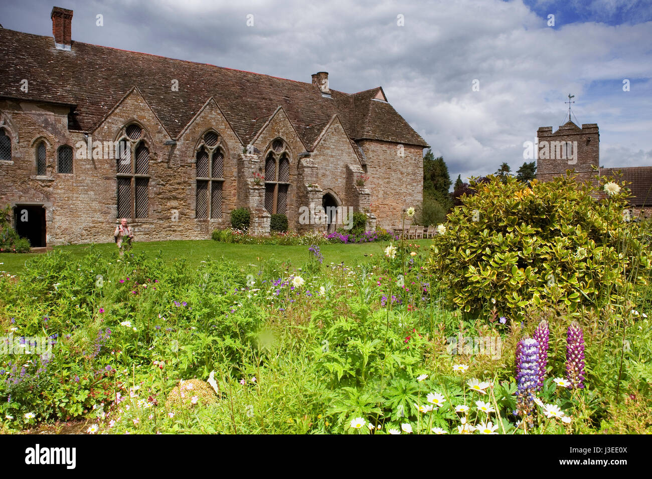 El patio interior, gran salón del siglo XIII y la torre de la iglesia, vistos desde el otro lado de la gloriosa jardineras, Stokesay Castle, Shropshire, Inglaterra, Reino Unido. Foto de stock