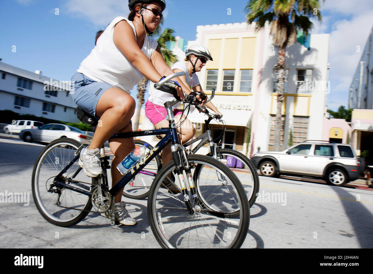 Miami Beach Florida, Ocean Drive, paseo en bicicleta comunitaria, casco, seguridad, deporte, fitness, negros africanos minoría étnica, adultos mujeres mujeres Foto de stock