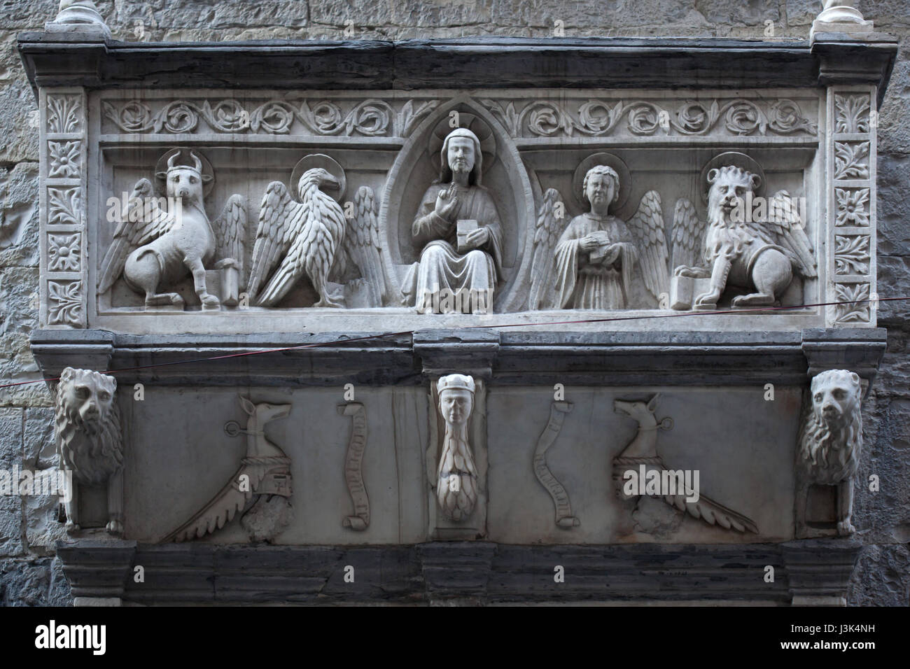 Jesús Cristo en Majestad rodeado por las criaturas del tetramorfos representado en el friso de mármol en el balcón de Génova la catedral (Duomo di Genova) en Génova, Liguria, Italia. Foto de stock