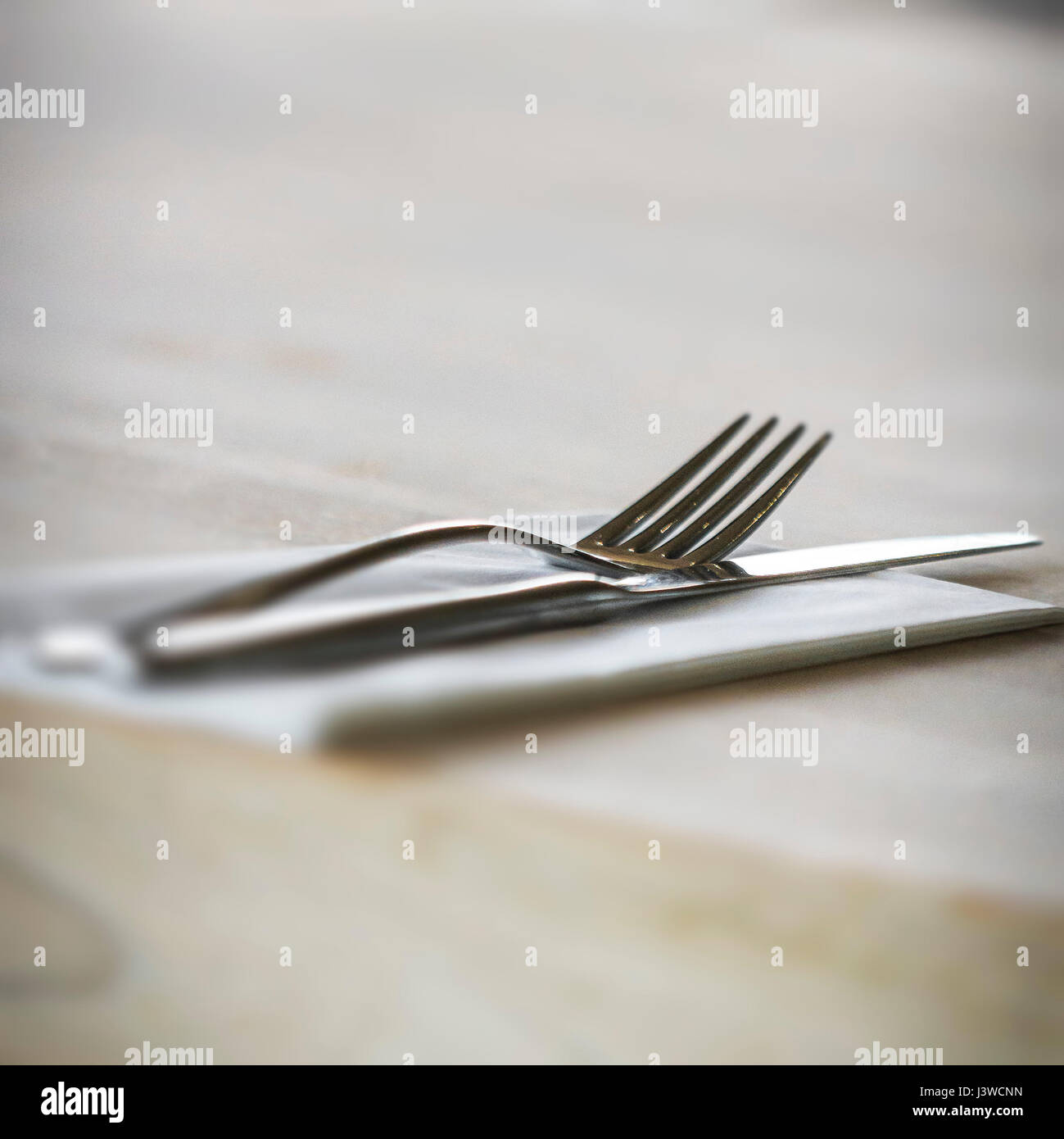 Un tenedor y un cuchillo con una servilleta Place Setting Restaurante utilizado Foto de stock