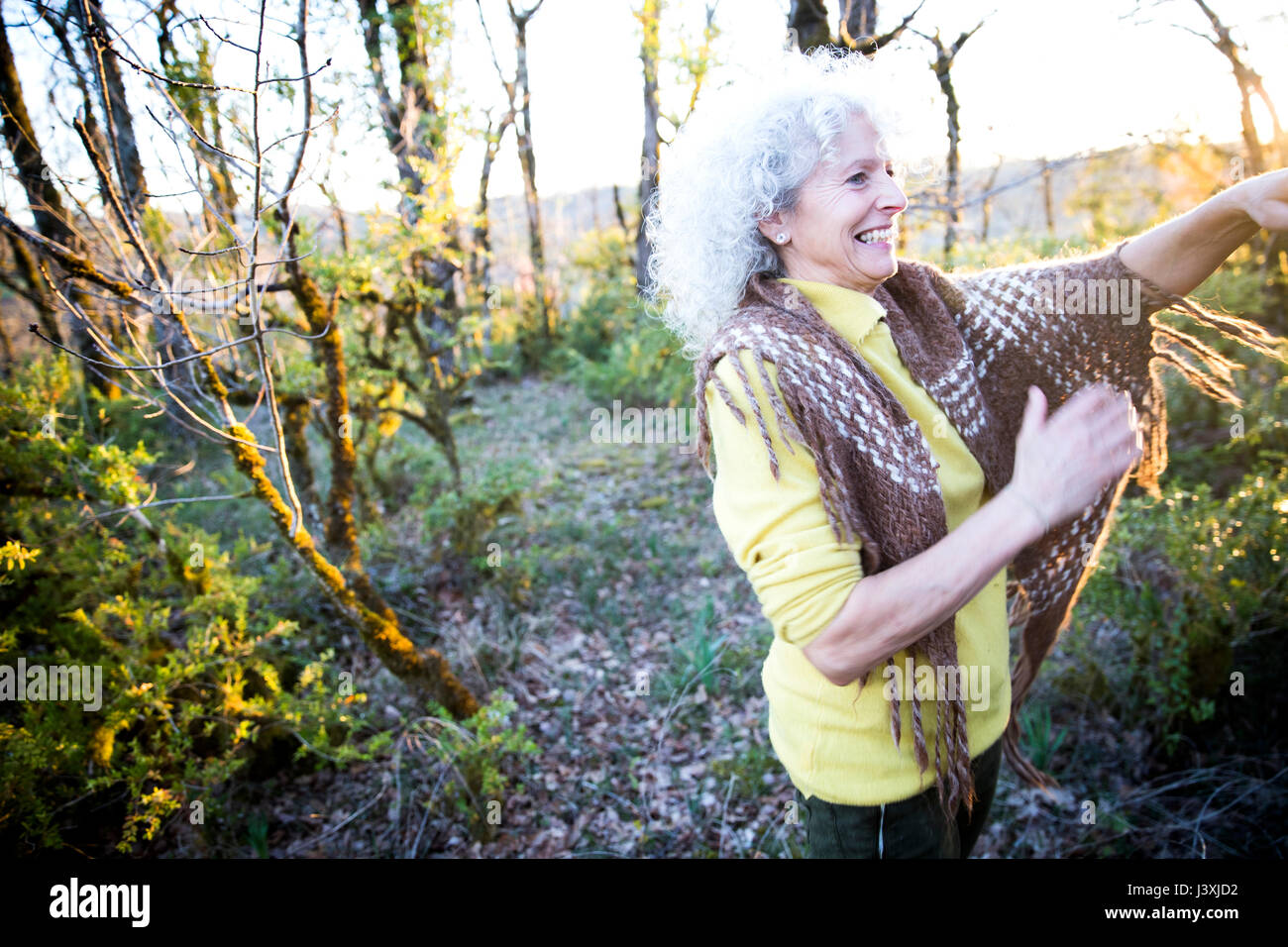 Feliz mujer madura en woodland scrub al atardecer Foto de stock