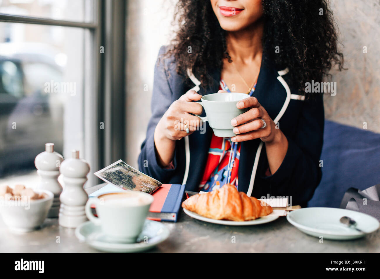 Captura recortada de la mujer sosteniendo la taza de café en la cafetería Foto de stock