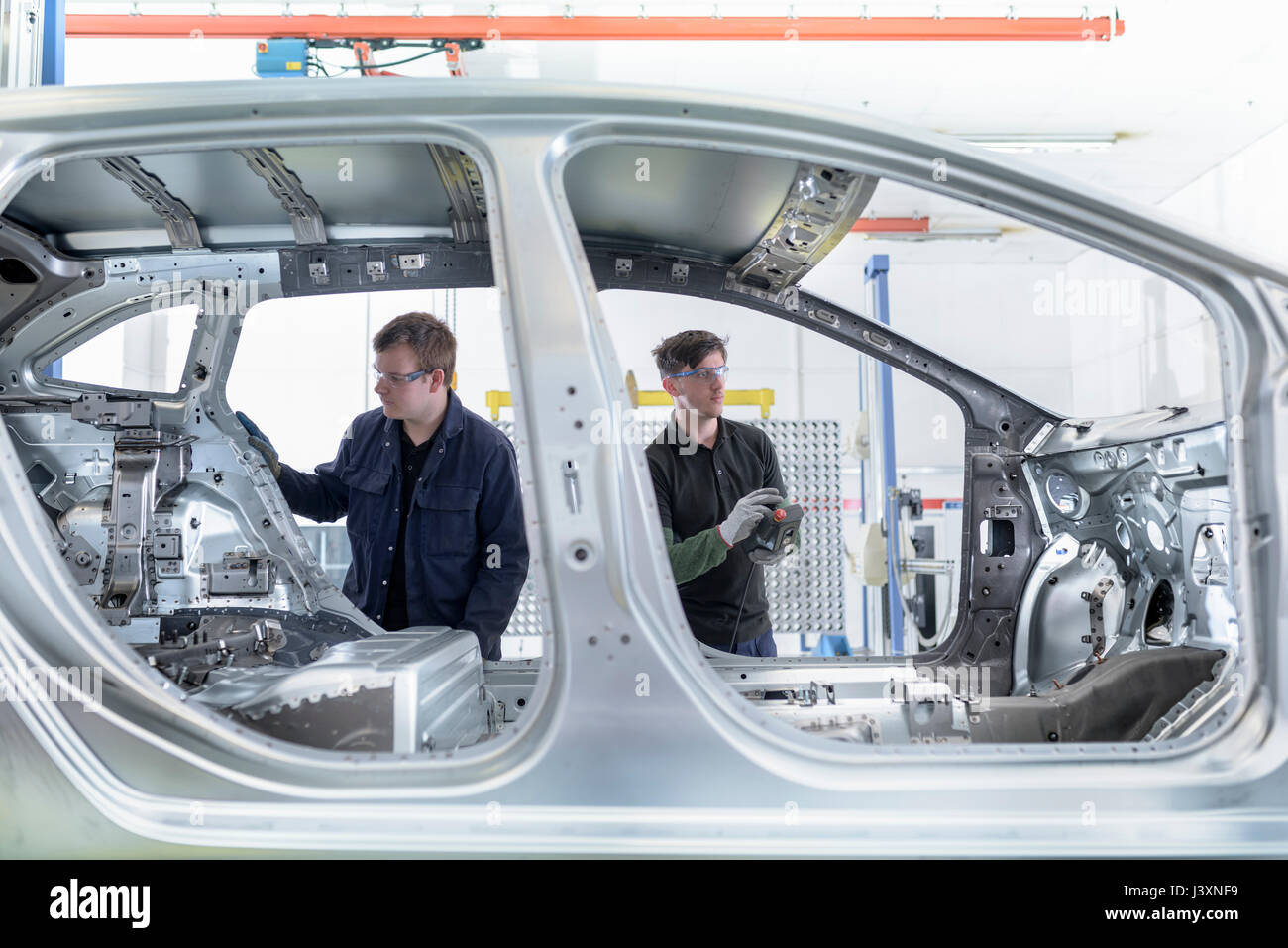 La carrocería del coche de medición de ingenieros de aprendiz en la fábrica de automóviles Foto de stock