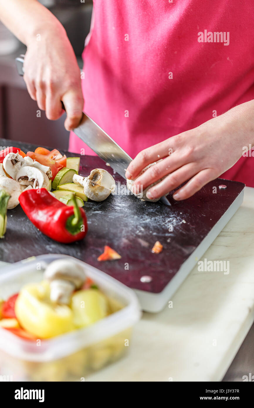 Chef es cortar verduras frescas y deliciosas para cocinar Foto de stock