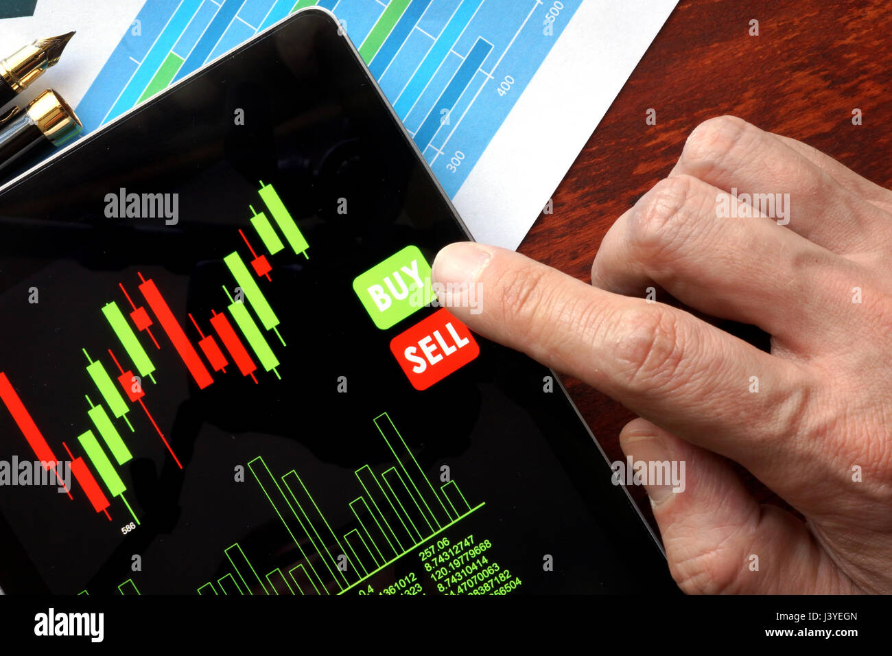 Concepto de comercio en línea. Tablet con datos de la bolsa de valores financieros y el dedo. Foto de stock