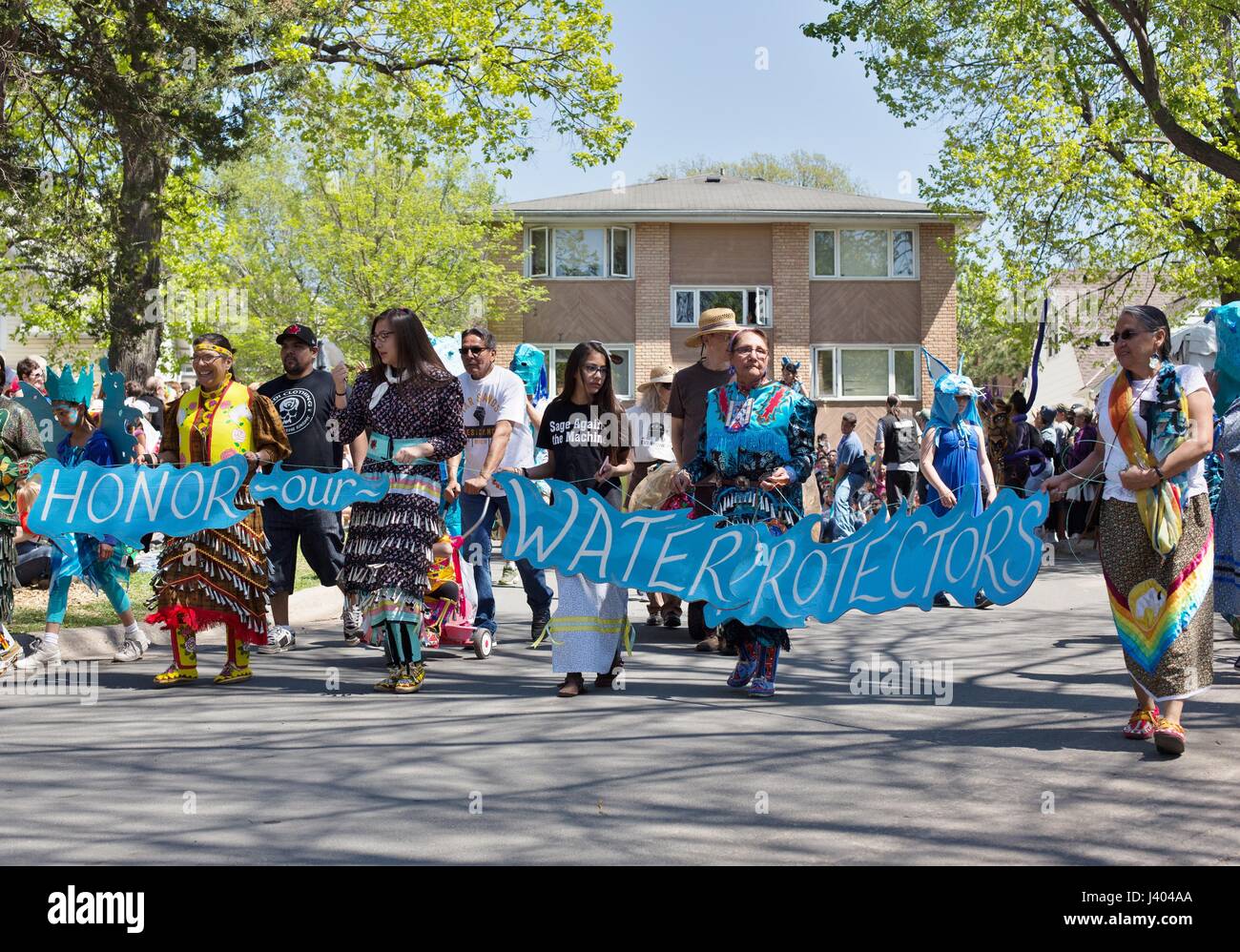 Un grupo de mujeres nativas americanas marchando con una pancarta que dice 'honrar a nuestros protectores de agua' en la Mayday Parade en Minneapolis, Minnesota, USA. Foto de stock
