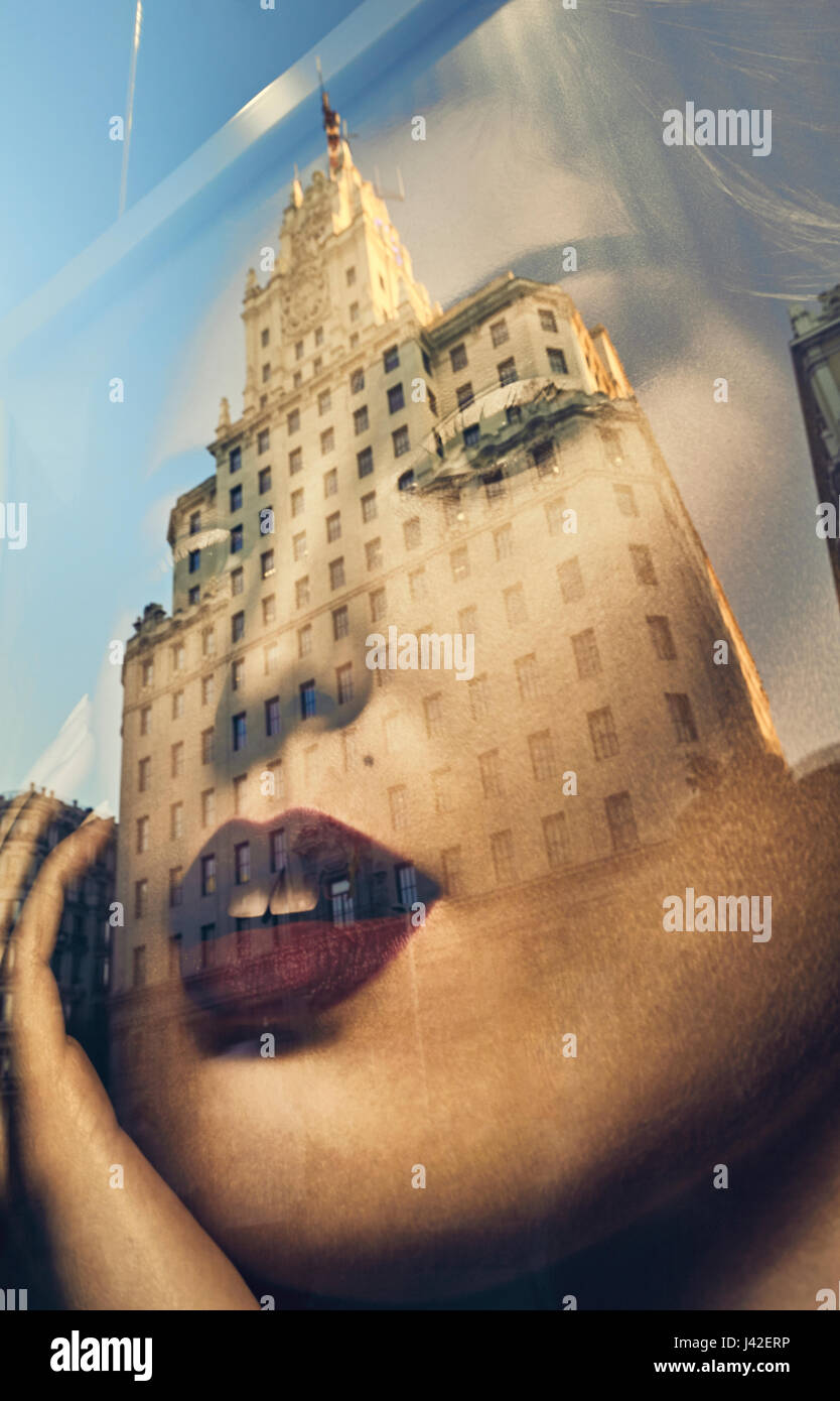 Edificio telefónica reflexión sobre una ventana shop moda cartel en la Avenida Gran Vía. Madrid. España Foto de stock