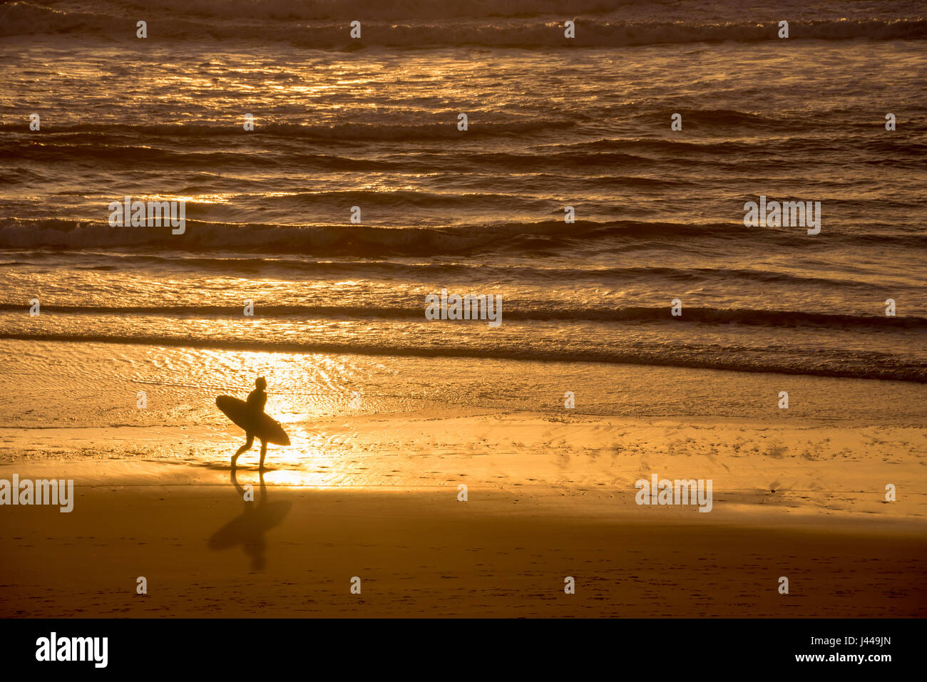 Silueta de un surfista al atardecer sobre el océano atlántico, Lacanau Francia Foto de stock