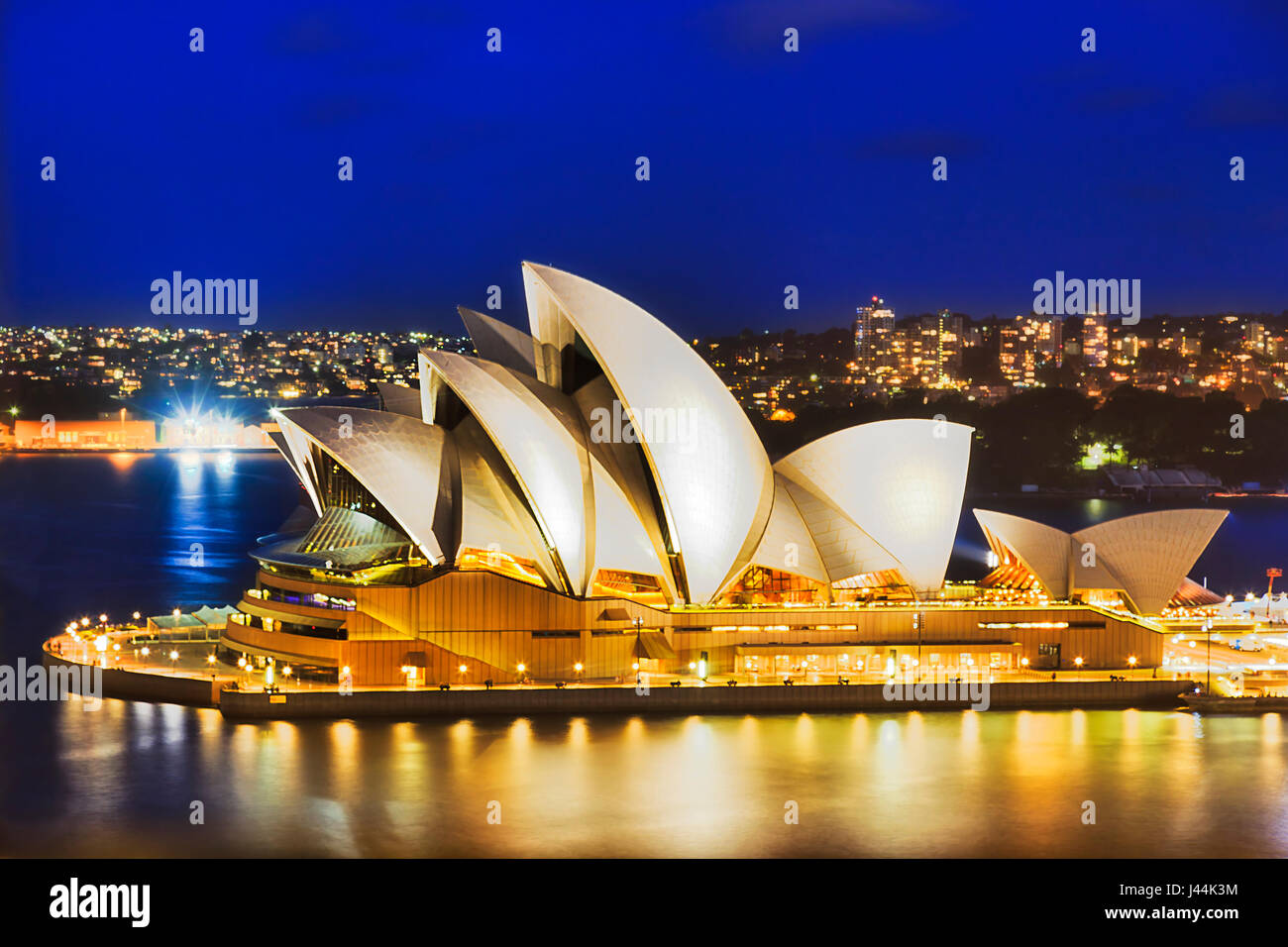 Sydney, Australia - 21 de febrero de 2016: Sydney Opera House icónico buiilding con iluminación brillante visto desde Sydney Harbour Bridge al atardecer. Foto de stock