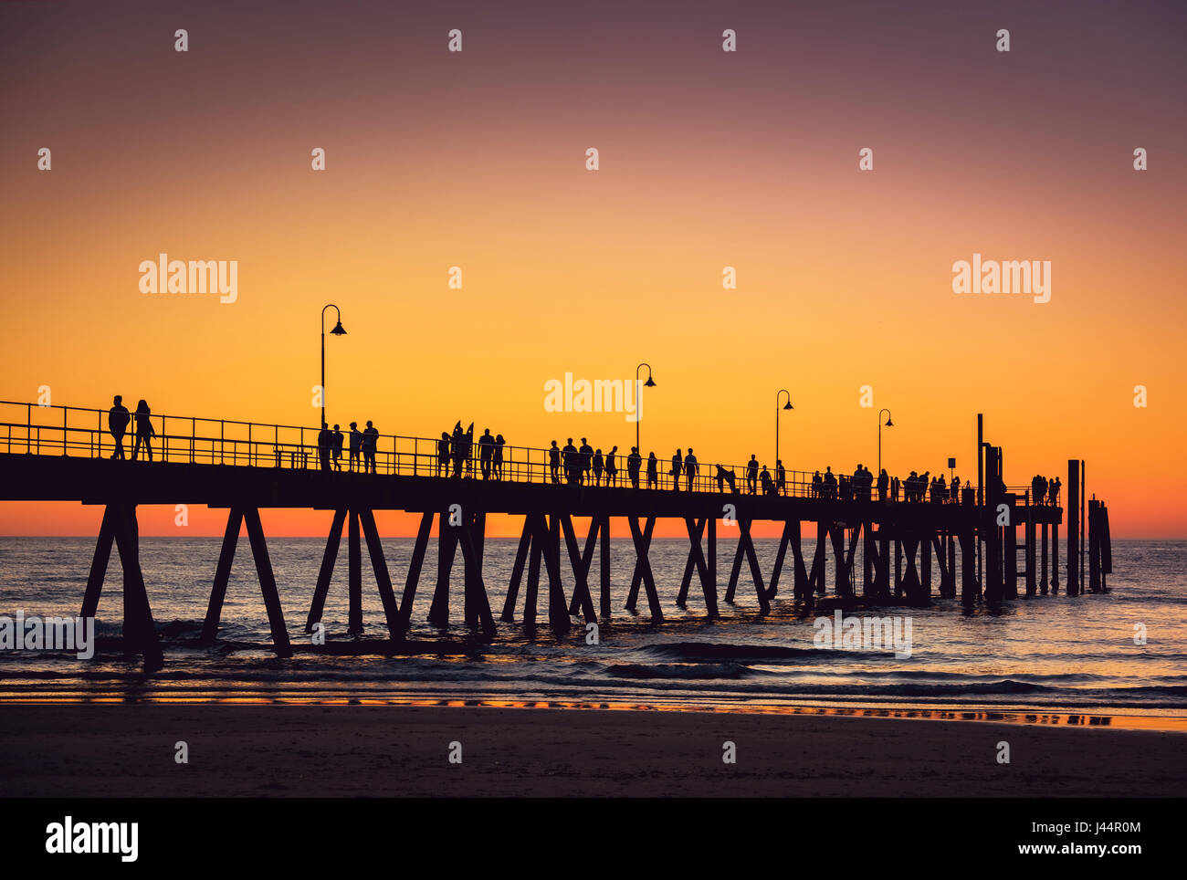 La playa de Glenelg jetty con gente al atardecer, Adelaide, Australia del Sur Foto de stock
