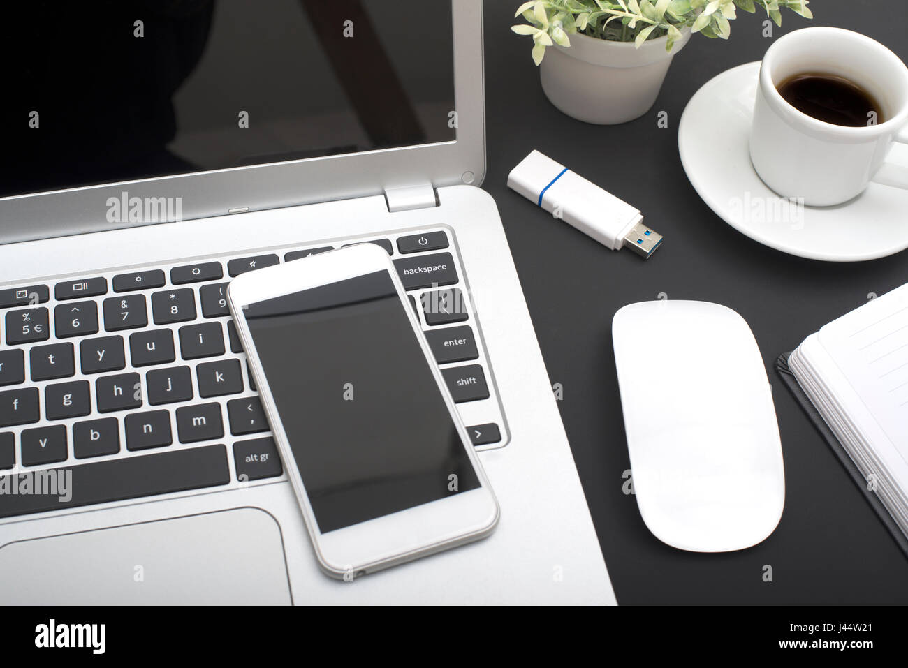 Smartphone y el ordenador portátil boceto en black mesa de oficina Foto de stock