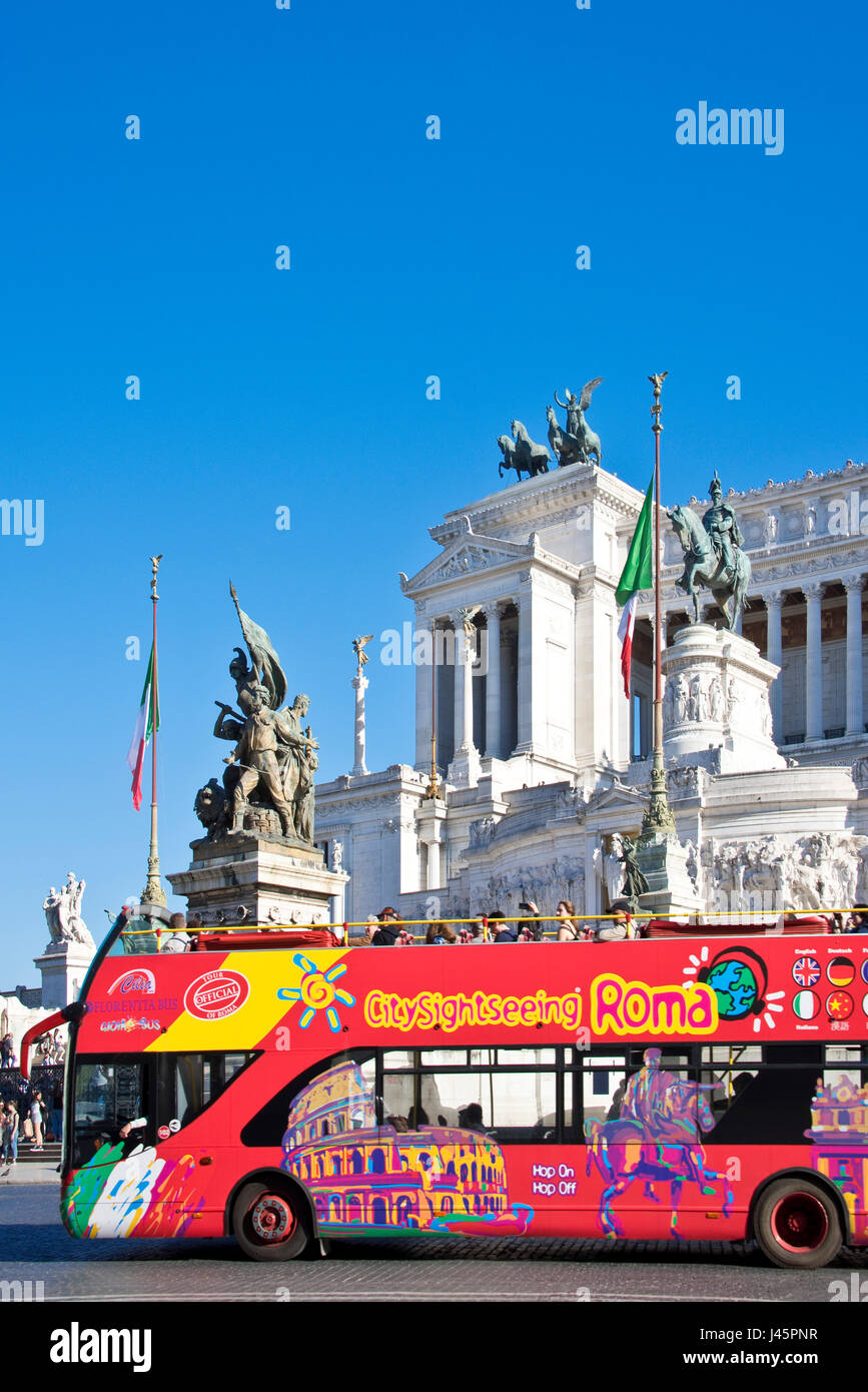 Altare della Patria o Monumento Nazionale en Roma Roma en un día soleado con un cielo azul y un pase de autobús turístico. Foto de stock