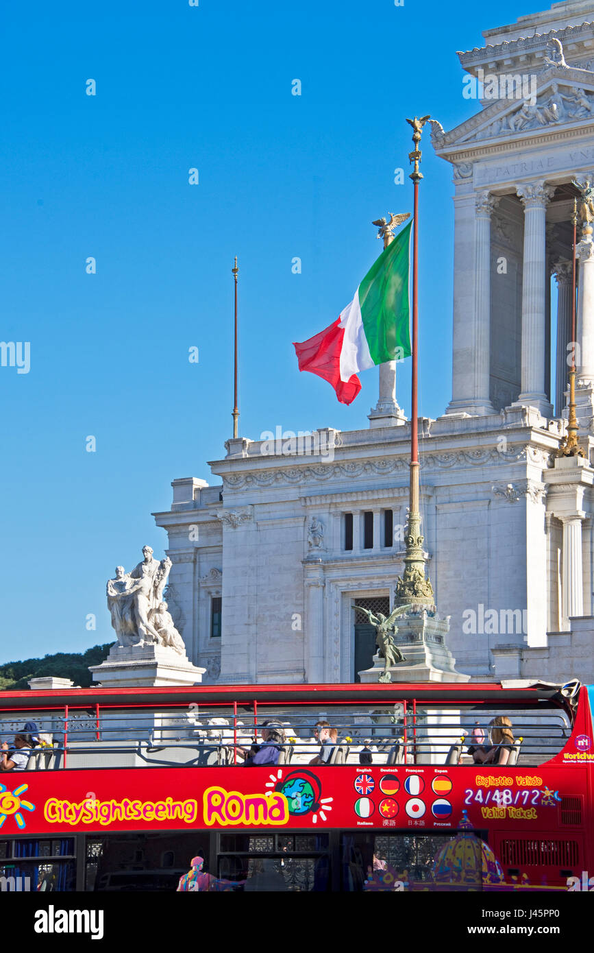 Altare della Patria o Monumento Nazionale en Roma Roma en un día soleado con un cielo azul y un pase de autobús turístico. Foto de stock