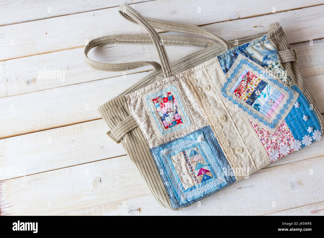 Hechos a mano, moda, accesorios concepto -flatlay de encantadoras mujeres bolsa hecha de pana y de la parte delantera de la costura en la técnica Patchwork con coloridos fragmentos ornamentados. Tiene dos correas, encajes y botón Foto de stock