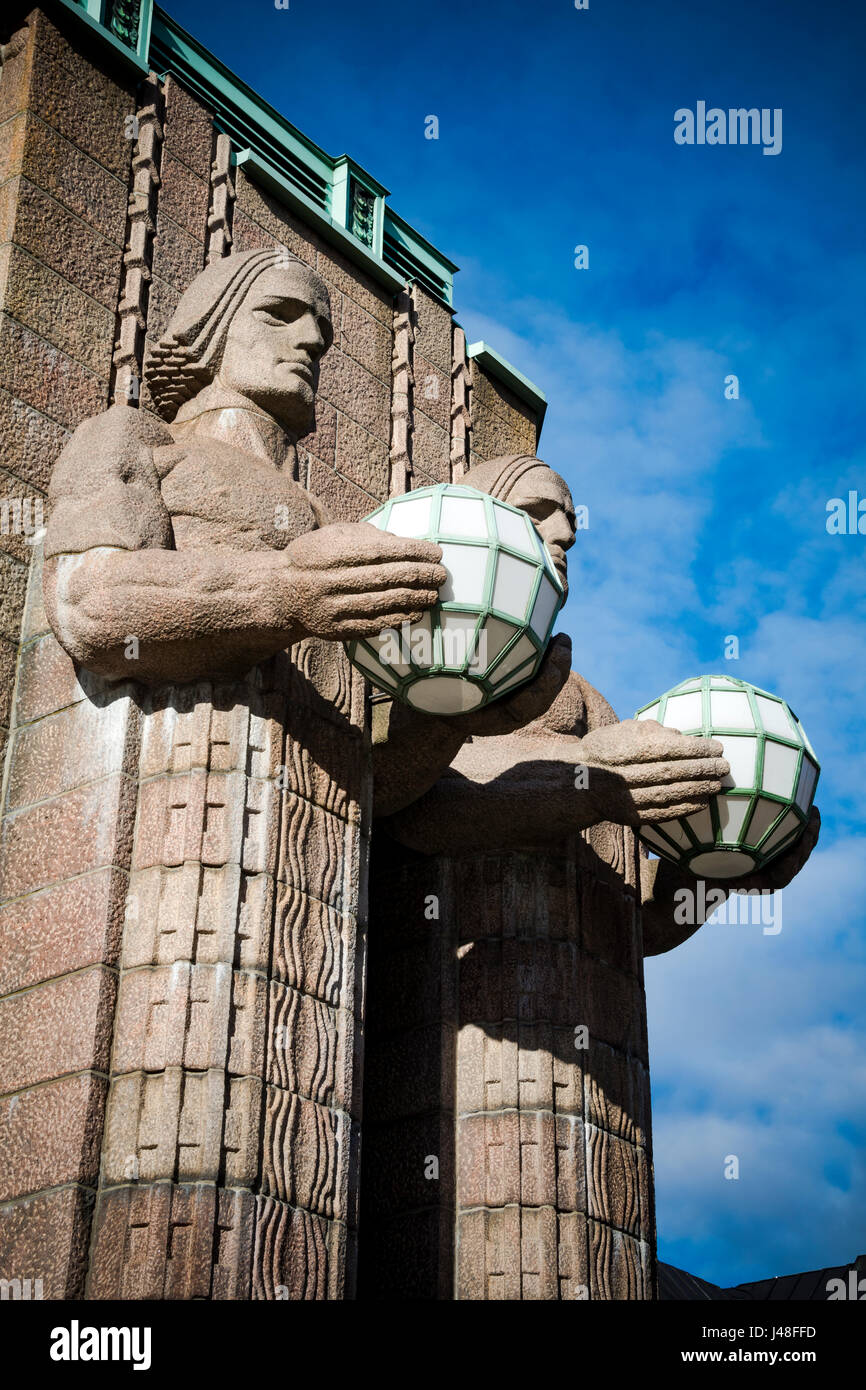 Estación de ferrocarril de Helsinki estatuas de granito sosteniendo lámparas Foto de stock