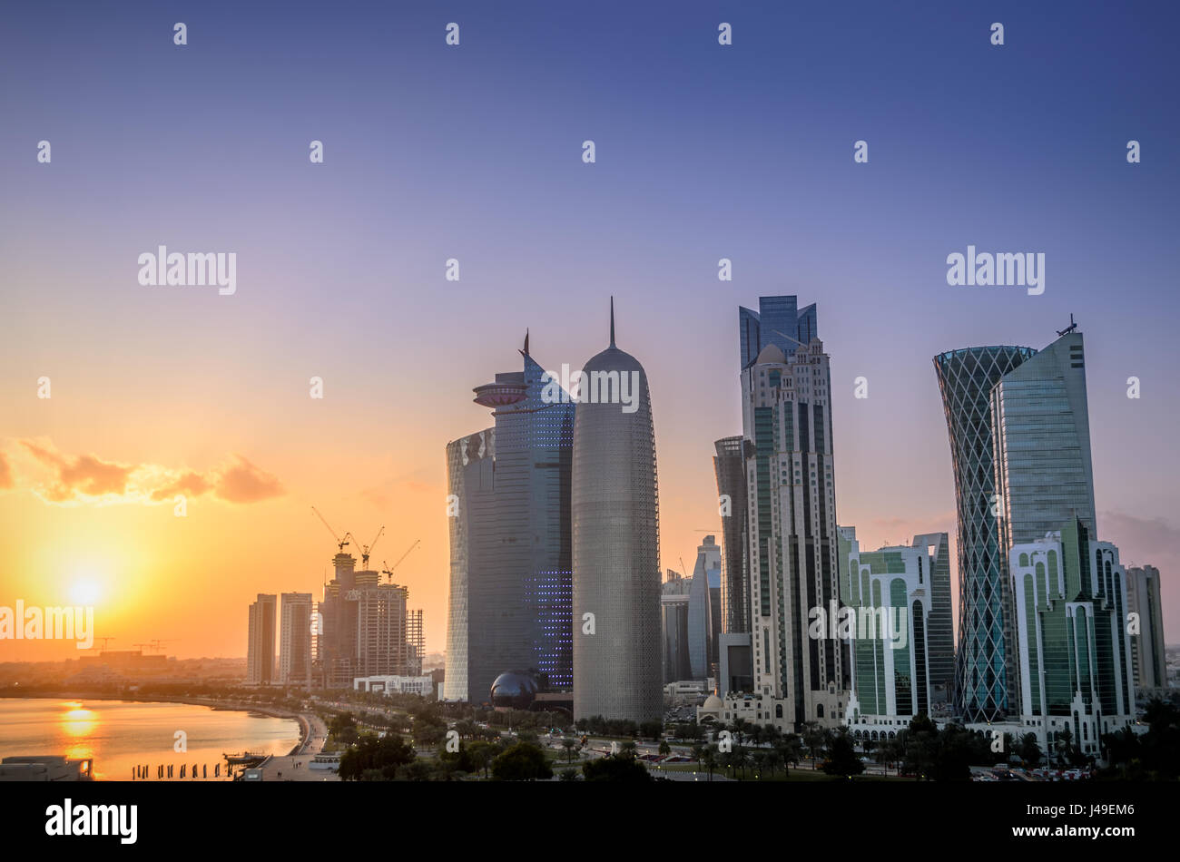 Los rascacielos en el horizonte del centro comercial de Doha, capital de Qatar, país del Golfo Arábigo al atardecer. Foto de stock