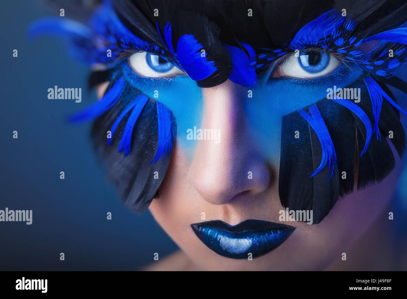 Hermosa mujer con maquillaje con plumas azul Fotografía de stock - Alamy