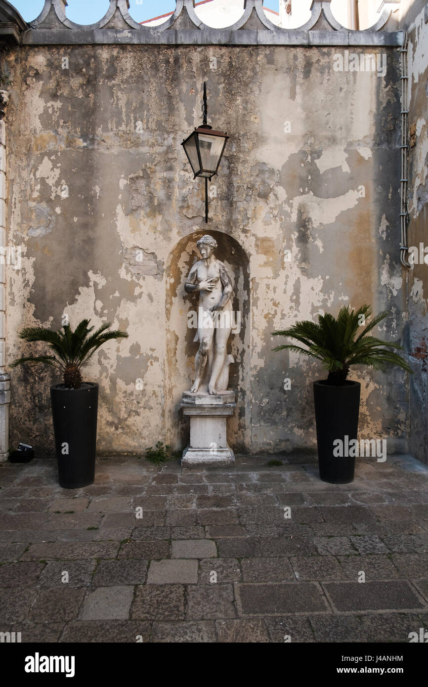Pequeño cuadrado en Venecia con n antigua estatua Foto de stock