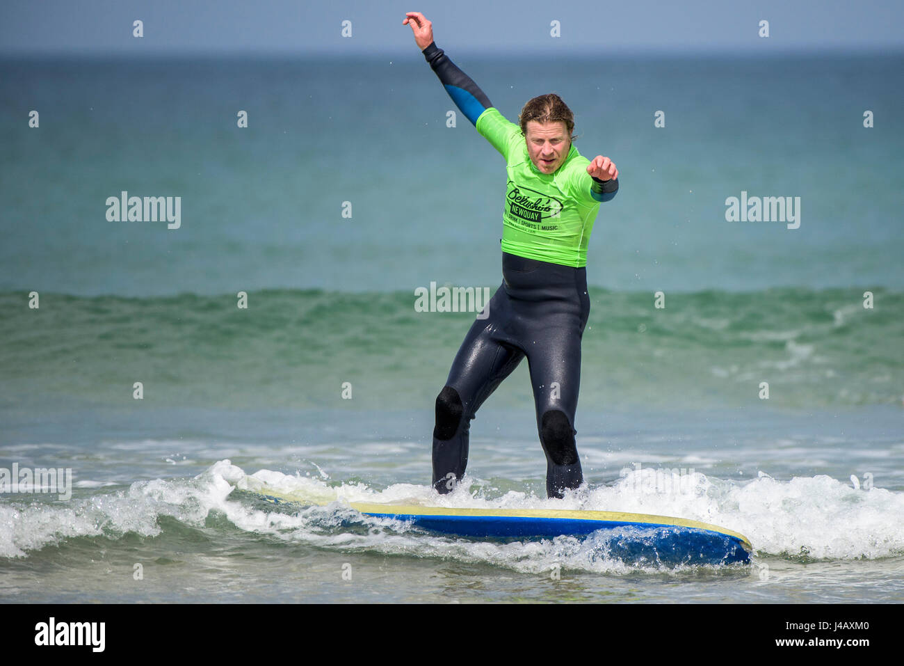 Un novato aprendiendo a surfear en la playa Fistral en Newquay Cornwall Surf surfista principiante la enseñanza aprendizaje Mar Mar Turismo Foto de stock