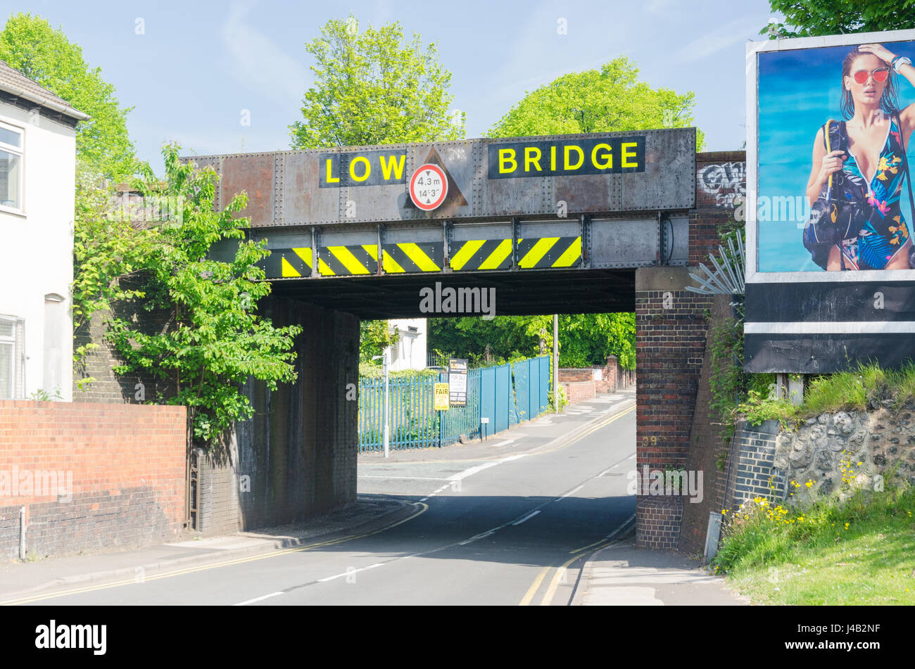 Puente de ferrocarril con 'baja' puente cruza un camino en Cradley Heath en el Black Country, West Midlands Foto de stock
