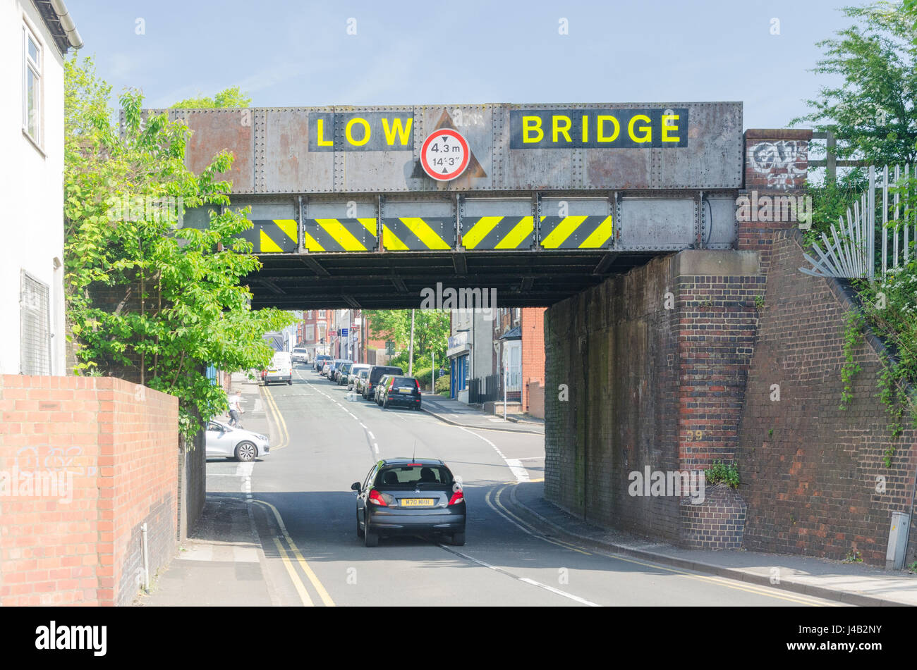Puente de ferrocarril con 'baja' puente cruza un camino en Cradley Heath en el Black Country, West Midlands Foto de stock