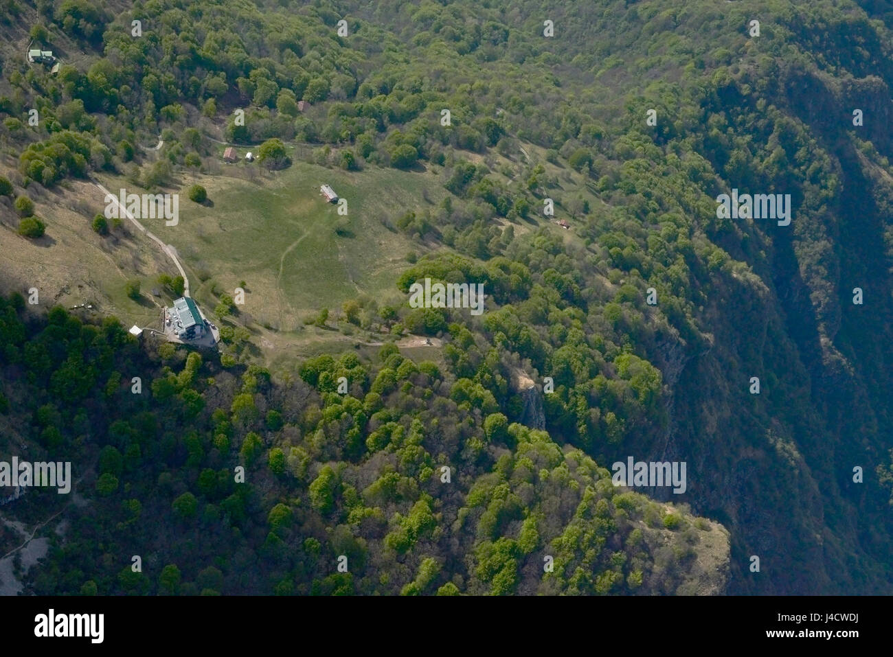 Toma aérea de un pequeño avión, de refugio de montaña en Canzo pico, filmado en un brillante día de primavera en Lombardía, Italia Foto de stock