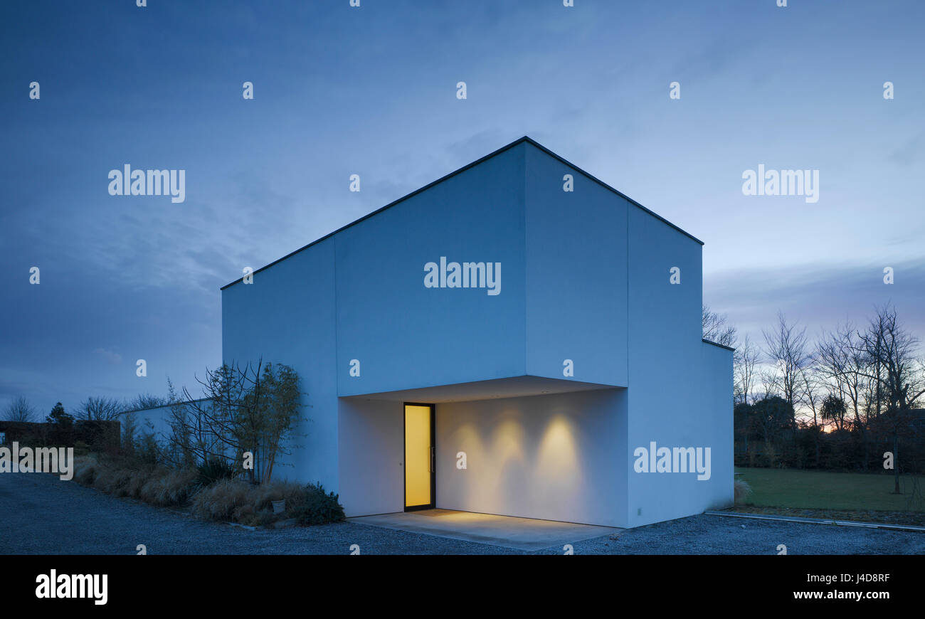 Vista noreste de casa con fachada, las plantas y la iluminación interior. Portmarnock House, Portmarnock, Irlanda. Arquitecto: Amanda hueso Arquitecto, 2010 Foto de stock